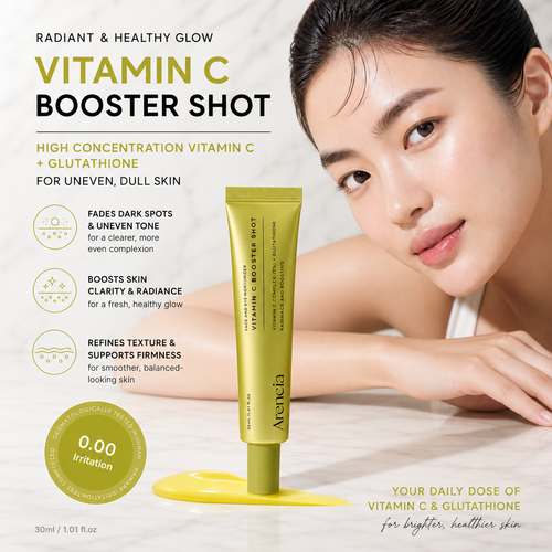 A cosmetic tube labeled 'Arenia Vitamin C Booster Shot' stands on a yellow gel pad against a light marble surface, with a woman's face and hand visible in the background. Text on the ad highlights high-concentration vitamin C and glutathione for uneven, dull skin.